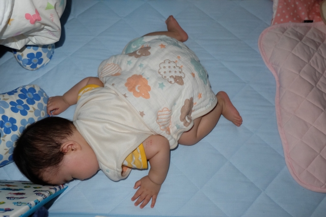 スリーパーを着た赤ちゃんが寝ている写真